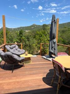 a wooden deck with an umbrella and tables and chairs at Isabella in Figari