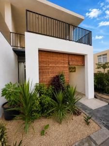 a white house with a brick wall and plants at Sea Esta in Le Morne