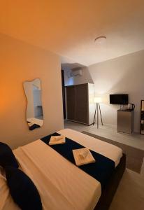 a hotel room with two beds and a television at Hotel AKSA in Prizren
