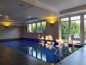 an indoor swimming pool with blue water in a house at Hotel Nuhnetal in Winterberg