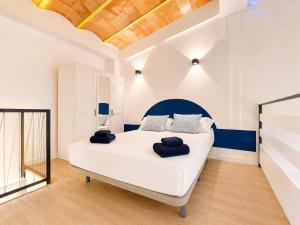 a bedroom with a large white bed with blue accents at Vientos de Tabarca 5 in Tabarca