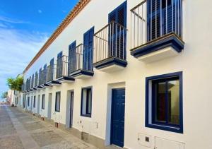 a row of buildings with blue doors and windows at Vientos de Tabarca 5 in Tabarca +36 photos