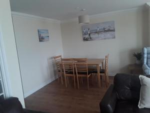 a living room with a dining room table and chairs at isleofmanholidayapartment in Douglas