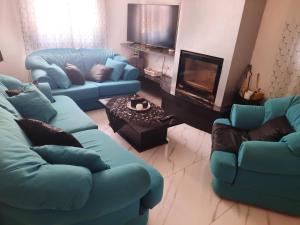 a living room with two blue couches and a fireplace at Tania's house in Tríkala