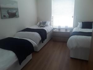 a bedroom with two twin beds and a window at isleofmanholidayapartment in Douglas +35 photos