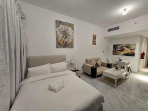 a bedroom with a large bed and a living room at شقة مصدر in Abu Dhabi