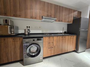 a kitchen with a washing machine and a refrigerator at شقة مصدر in Abu Dhabi