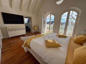 a bedroom with a large bed with a flat screen tv at Villa Löwe - Heated Indoor Pool, Spa & Wellness Estate near Basel in Kandern