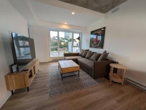 a living room with a couch and a tv at Suites Cobalt in Quebec City