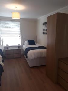 a small bedroom with a bed and a window at isleofmanholidayapartment in Douglas