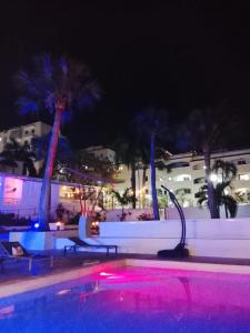 a swimming pool at night with palm trees at Hannabi Beach Hotel in Boca Chica
