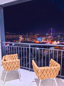 two chairs sitting on top of a balcony at night at Парк апарт-отел in Namangan