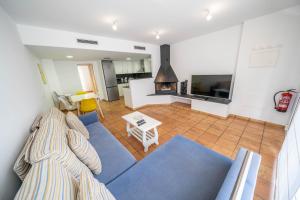 a living room with a blue couch and a fireplace at Mimoses Apartaments in Cadaqués