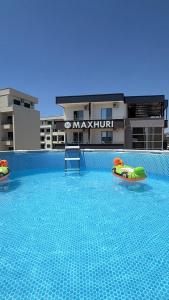 a swimming pool with two rafts in the middle of a building at Maxhuri Apartments in Ulcinj