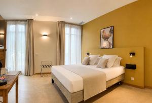 a bedroom with a large white bed in a room at LE PALMIER Aigues-Mortes Petite Camargue in Aigues-Mortes