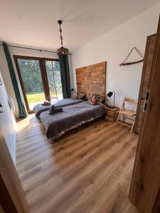 a bedroom with a bed and a large window at Przystanek Beztroska in Wydminy