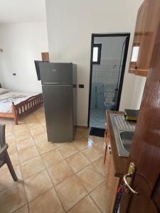 a kitchen with a refrigerator and a toilet in a room at ApartHotel Fahria Velipoje in Velipojë