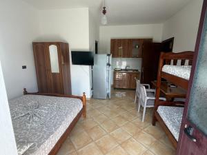 a room with a kitchen with a bed and a refrigerator at ApartHotel Fahria Velipoje in Velipojë