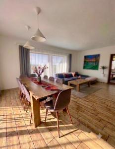 a living room with a wooden table and chairs at Domo Vila in Druskininkai +18 photos