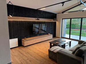 a living room with a couch and a flat screen tv at Akacia Chalet in Moieciu de Jos