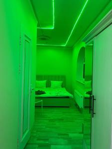 a green room with a bed and a green ceiling at Qoya in Fergana