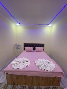 a bedroom with a bed with a purple ceiling at Qoya in Fergana +5 photos