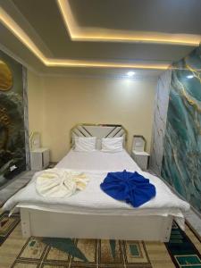 a bedroom with a white bed with blue bows on it at Qoya in Fergana