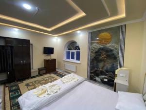 a bedroom with a bed and a painting on the wall at Qoya in Fergana
