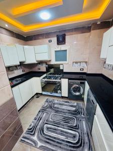 a kitchen with black and white cabinets and a dishwasher at XOtel in Dumyāţ al Jadīdah