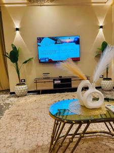 a living room with a tv and a coffee table at XOtel in Dumyāţ al Jadīdah