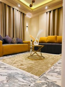 a living room with yellow couches and a table at XOtel in Dumyāţ al Jadīdah +1 photo