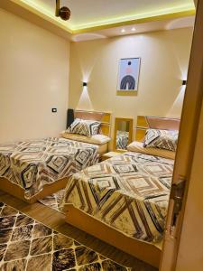 a room with two beds in a room at XOtel in Dumyāţ al Jadīdah