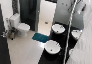 a bathroom with two sinks and a toilet at Paraíso Escarpas do Lago 1 - Capitólio in Capitólio +10 photos