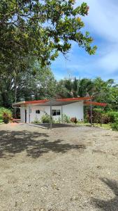 a small white house with trees in the background at Villas Pura Vida - Mango in Puntarenas
