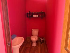 a red bathroom with a toilet and a sink at Sky Dome Peru in Cusco