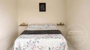 a small bedroom with a bed with a blanket at Pousada Horizontes de Bonito in Bonito