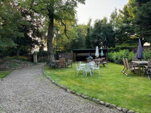 a garden with tables and chairs and a table with umbrellas at Piper Cottage, Bilbrough, York in Bilbrough