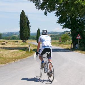 a man riding a bike down a road at B&B Il Molinello in Asciano