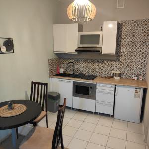 a small kitchen with a table and a microwave at Redkot 40A in Zielona Góra