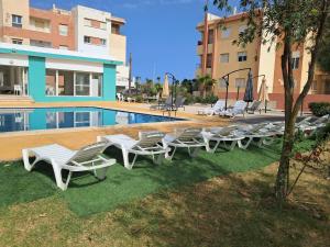 a group of lounge chairs next to a swimming pool at Le Nid Côtier in Briech