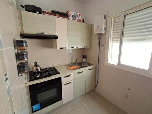 a small kitchen with a stove and a sink at Le Nid Côtier in Briech