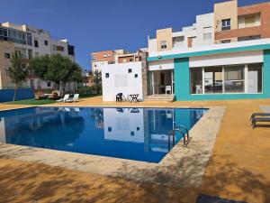 a swimming pool in front of a building at Le Nid Côtier in Briech