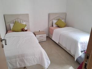 two beds sitting next to each other in a bedroom at Le Nid Côtier in Briech +15 photos