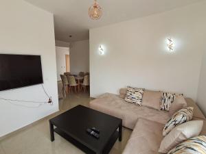 a living room with a couch and a flat screen tv at Le Nid Côtier in Briech
