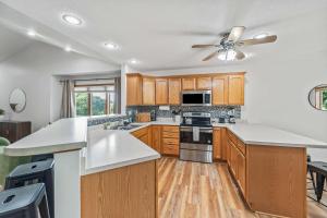 a kitchen with wooden cabinets and a ceiling fan at Des Moines 4BR Family Getaway in Des Moines +33 photos