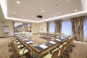 una gran sala de reuniones con una mesa larga y sillas en Parkhotel Wittekindshof, en Dortmund