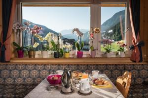 a table with food and flowers on a window sill at Garni Toni in Ortisei