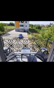 a balcony with chairs and a table and a building at STAN NA DAN Stara Pazova in Stara Pazova