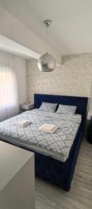 a bedroom with a bed with a blue comforter at Apartman Vaske 2 sa GARAŽOM in Brčko