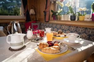 a breakfast table with a plate of pastries and orange juice at Garni Toni in Ortisei +13 photos